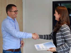 un candidat serre la main lors d'un entretien d'embauche réussi grâce à la correction de son CV