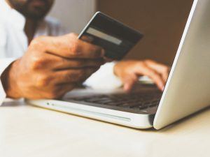 un homme paye sa correction en ligne par carte bleue