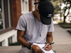 un jeune homme écrit un récit avant de le faire corriger