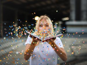 Une jeune fille tient un livre ouvert, ravie que la mise en page soit possible avec Correction En Ligne